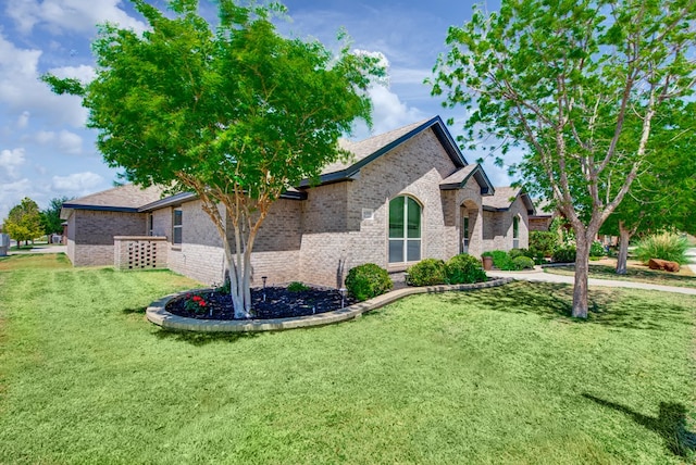 view of front of house featuring a front lawn and brick siding