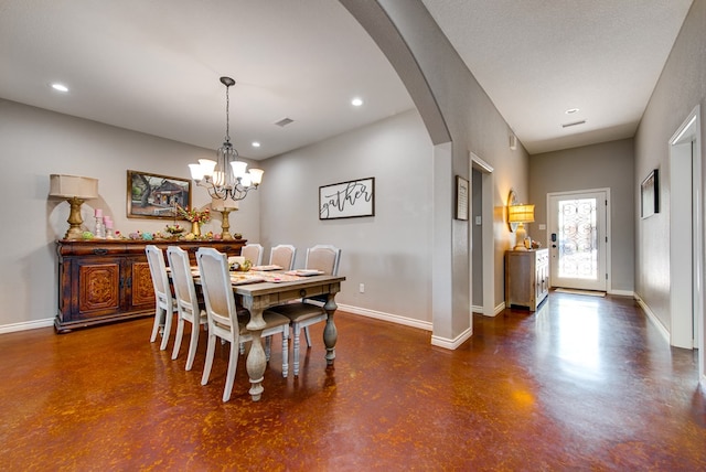 dining area featuring finished concrete floors, arched walkways, an inviting chandelier, baseboards, and recessed lighting