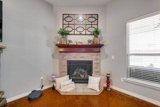 room details featuring finished concrete flooring, baseboards, and a fireplace