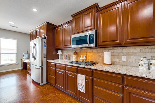 kitchen with baseboards, visible vents, backsplash, and appliances with stainless steel finishes