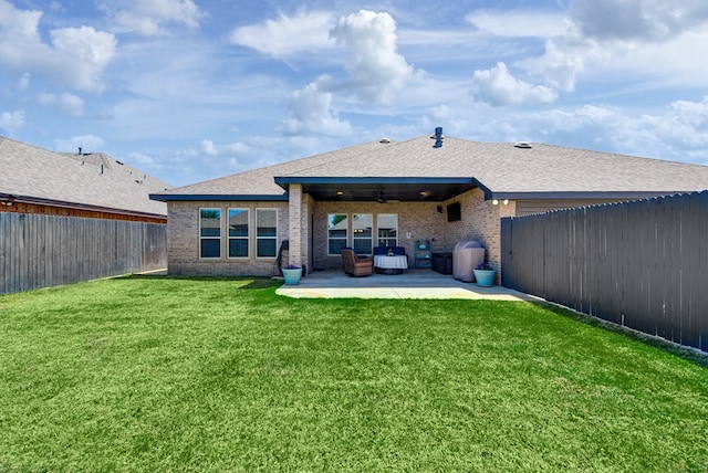 back of house with a lawn, a fenced backyard, brick siding, and a patio