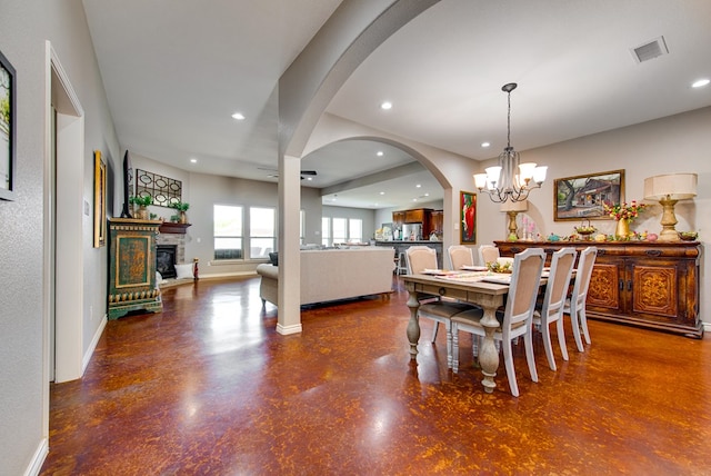 dining space featuring recessed lighting, a stone fireplace, finished concrete flooring, and baseboards