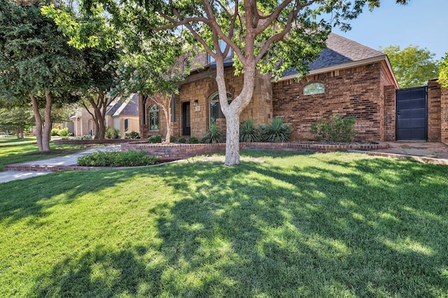 1102 Silverton Dr, Midland, TX 79705 - view of front of home featuring a front lawn, a shingled roof, and brick siding