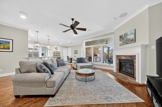 1102 Silverton Dr, Midland, TX 79705 - living area featuring wood finished floors, a ceiling fan, a glass covered fireplace, crown molding, and recessed lighting