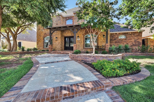 1102 Silverton Dr, Midland, TX 79705 - view of front facade featuring french doors, stone siding, and a shingled roof