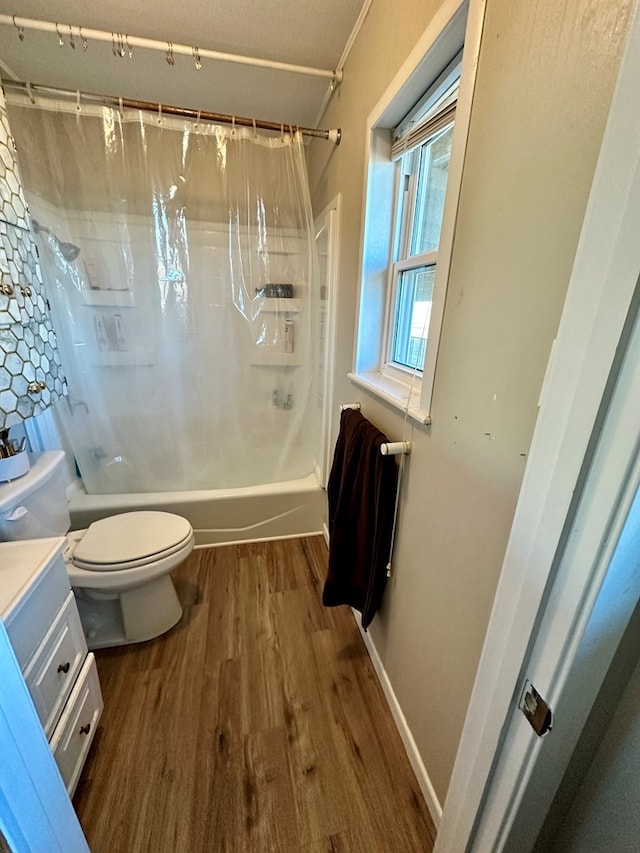 full bathroom with hardwood / wood-style flooring, shower / tub combo with curtain, vanity, and toilet