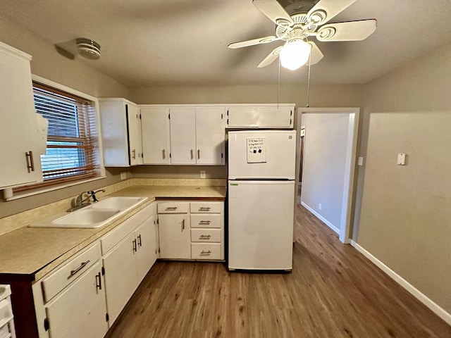 kitchen with sink, white cabinetry, white refrigerator, dark hardwood / wood-style flooring, and ceiling fan