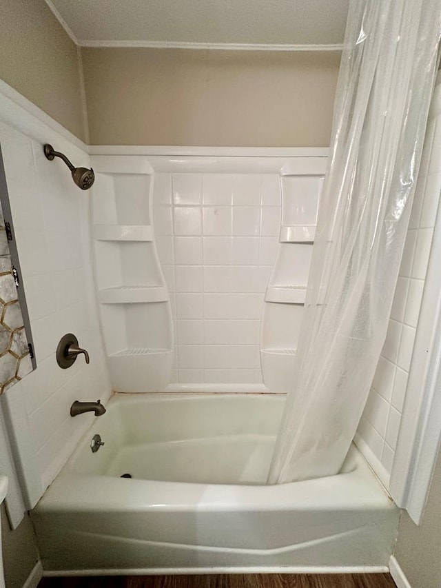 bathroom with hardwood / wood-style floors and shower / bath combo with shower curtain