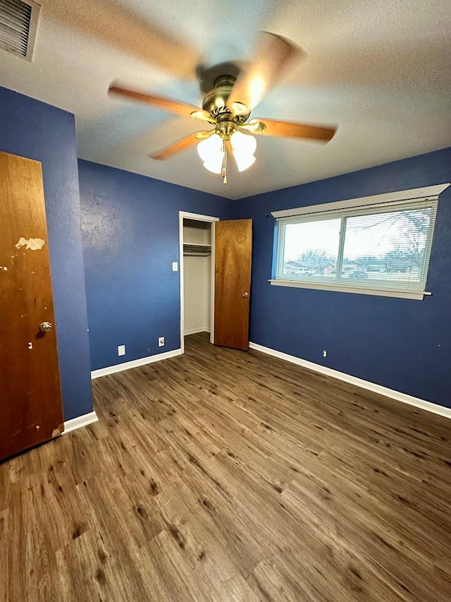 unfurnished bedroom featuring hardwood / wood-style floors, a textured ceiling, and ceiling fan