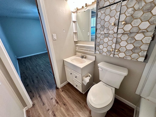 bathroom with vanity, toilet, and hardwood / wood-style floors