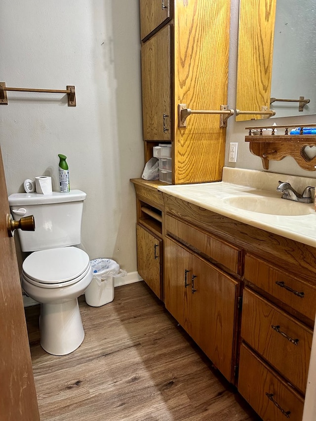 bathroom with wood-type flooring, toilet, and vanity