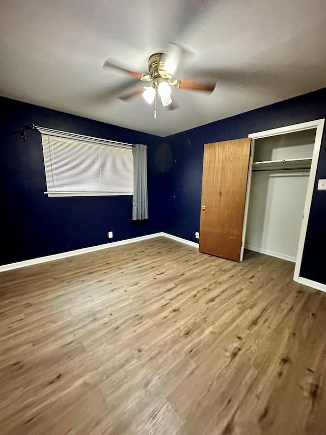 unfurnished bedroom featuring light hardwood / wood-style flooring, a closet, and ceiling fan