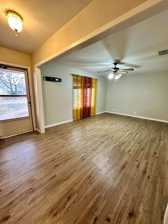 interior space with hardwood / wood-style flooring, a textured ceiling, and ceiling fan