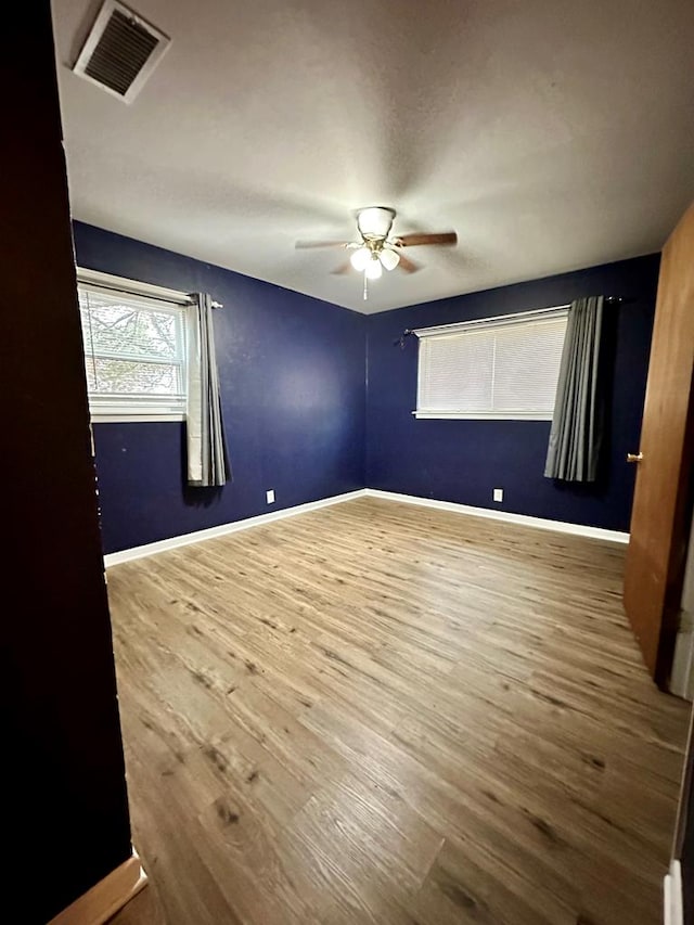 unfurnished room with hardwood / wood-style flooring and ceiling fan