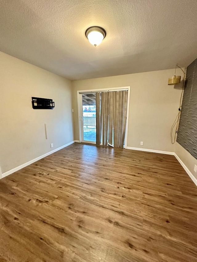 unfurnished room featuring hardwood / wood-style flooring and a textured ceiling