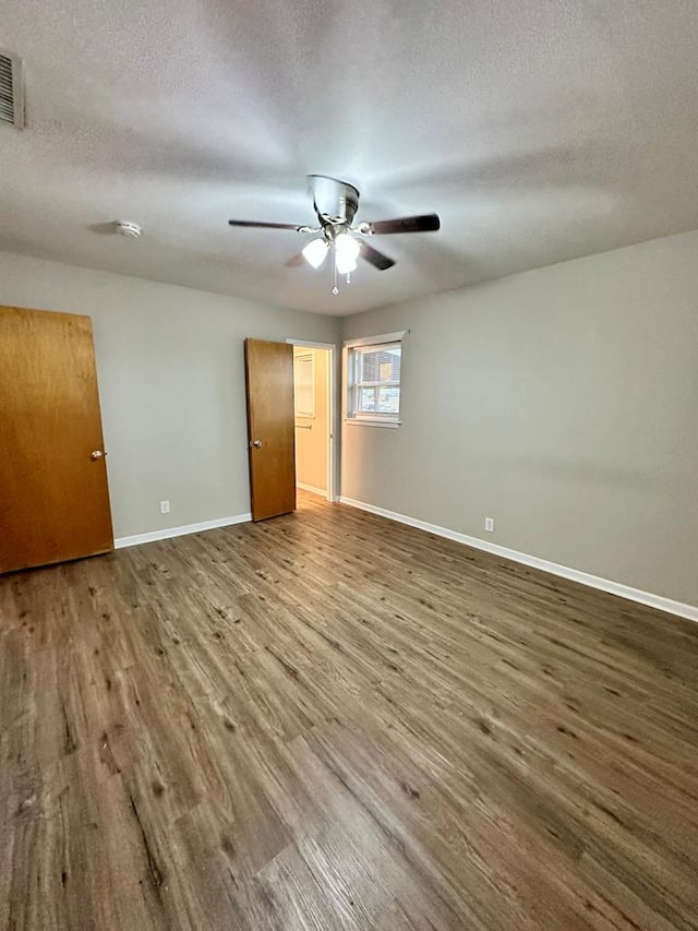 unfurnished room featuring ceiling fan, hardwood / wood-style flooring, and a textured ceiling