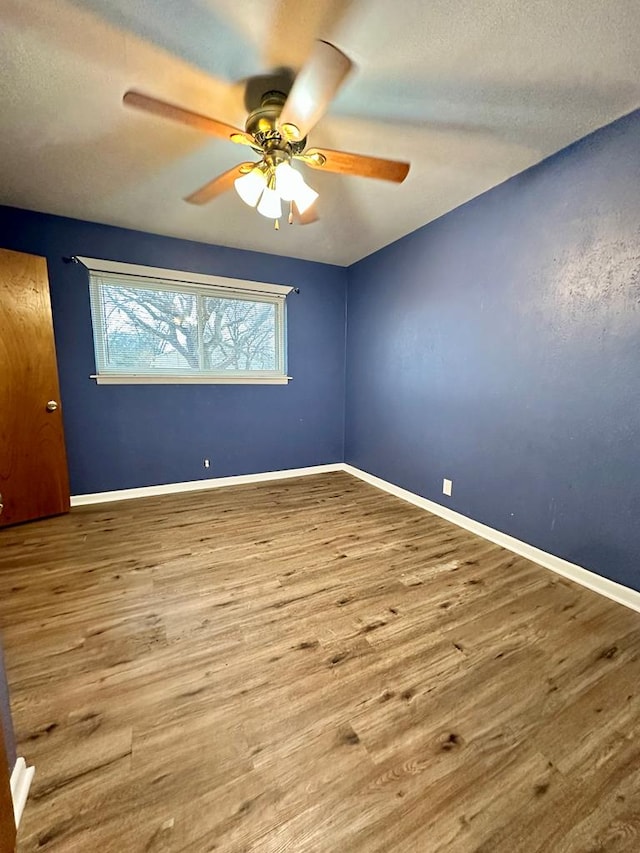 spare room with hardwood / wood-style flooring and ceiling fan