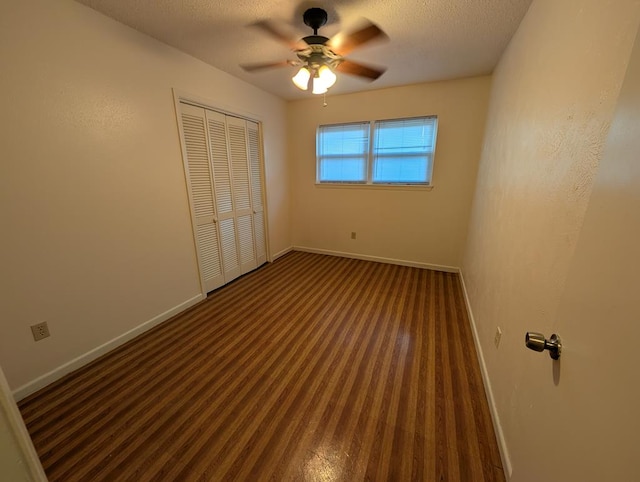 unfurnished bedroom featuring baseboards, a closet, ceiling fan, carpet, and a textured ceiling