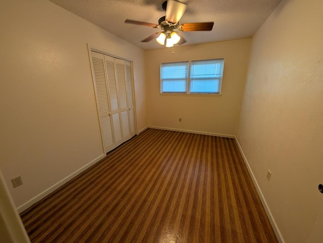 unfurnished bedroom featuring baseboards, carpet flooring, a closet, ceiling fan, and a textured ceiling