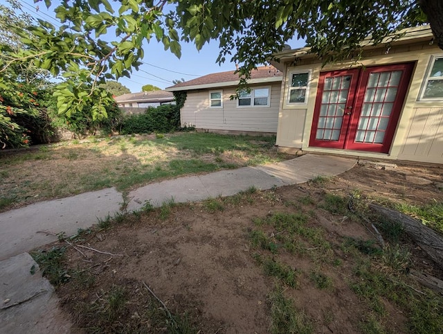 view of grassy yard with french doors