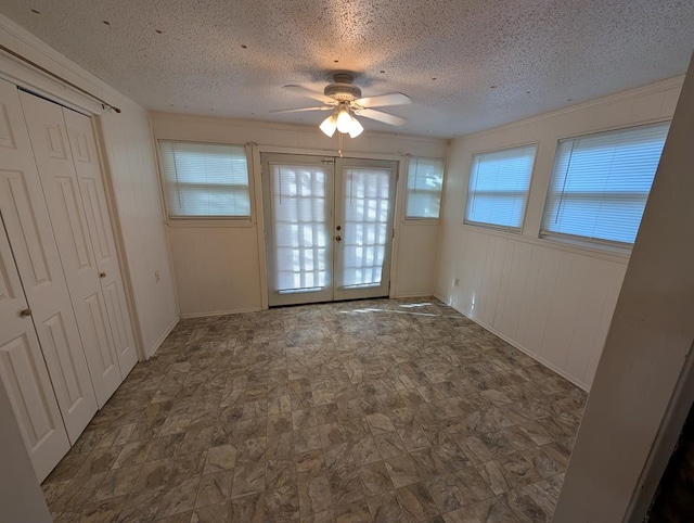 unfurnished bedroom with french doors, a textured ceiling, and ceiling fan