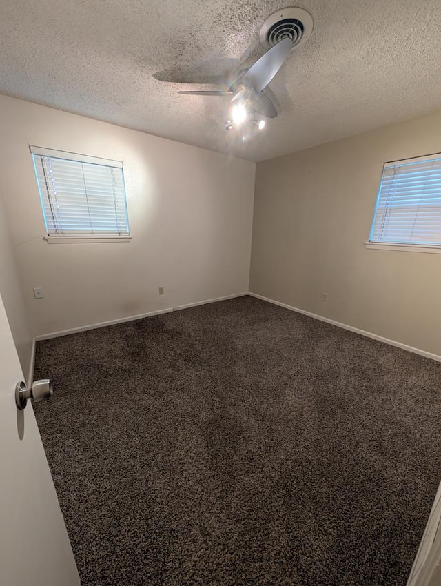 carpeted spare room with a textured ceiling, ceiling fan, and baseboards