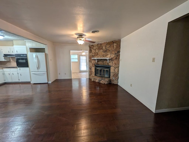 unfurnished living room featuring a ceiling fan, dark wood-style flooring, a fireplace, and baseboards