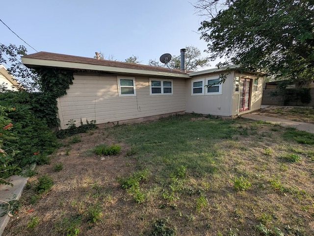 rear view of property with a yard