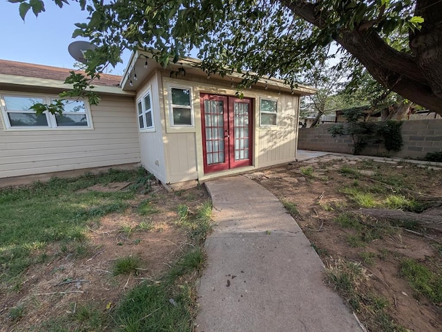 view of outbuilding featuring french doors and fence