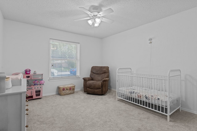 2821 Goddard Pl, Midland, TX 79705 - carpeted bedroom with a nursery area, a textured ceiling, ceiling fan, and baseboards