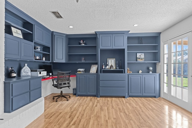 2821 Goddard Pl, Midland, TX 79705 - office featuring built in desk, healthy amount of natural light, light wood-style flooring, and a textured ceiling