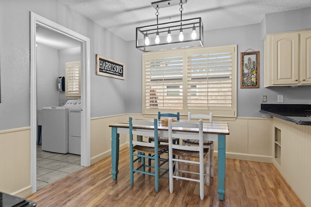 2821 Goddard Pl, Midland, TX 79705 - dining area with wainscoting, a textured ceiling, washing machine and clothes dryer, and light wood-style floors