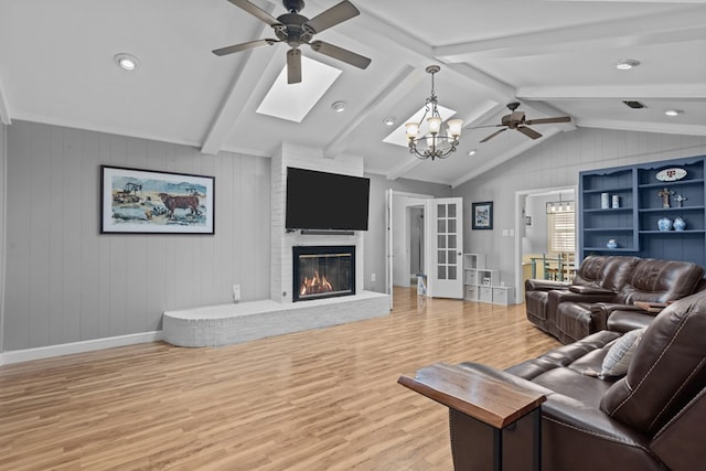 2821 Goddard Pl, Midland, TX 79705 - living area with a ceiling fan, light wood finished floors, a skylight, a brick fireplace, and a chandelier