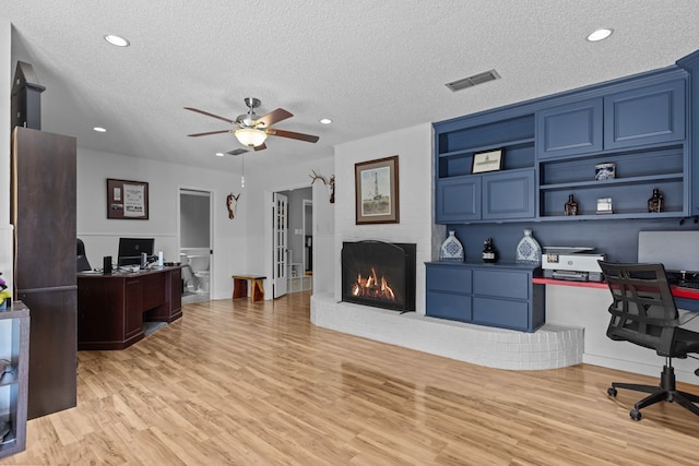 2821 Goddard Pl, Midland, TX 79705 - home office with a textured ceiling, a ceiling fan, light wood finished floors, a fireplace, and recessed lighting
