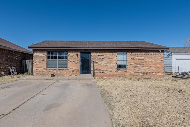 ranch-style home featuring brick siding and a shingled roof