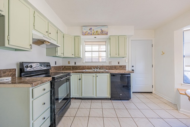 kitchen with under cabinet range hood, green cabinetry, black appliances, and a sink