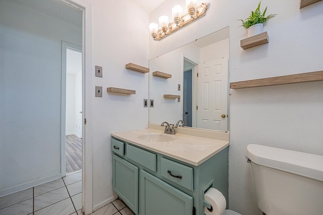 bathroom with baseboards, toilet, marble finish floor, and vanity