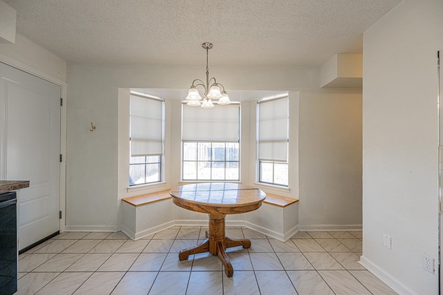 dining area with a textured ceiling, plenty of natural light, baseboards, and a chandelier