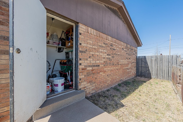 exterior space featuring fence and brick siding