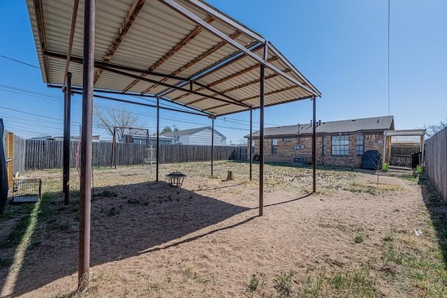 view of yard featuring a detached carport and a fenced backyard