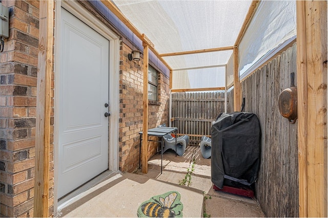 property entrance featuring brick siding and fence