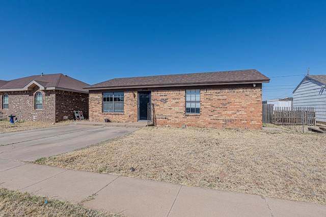 ranch-style house featuring fence and brick siding