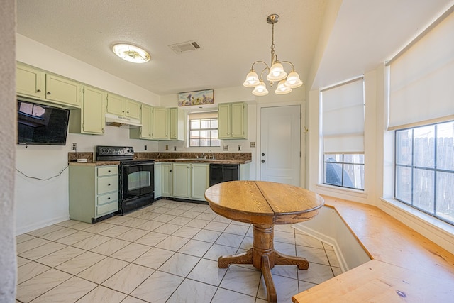 kitchen with visible vents, green cabinetry, black appliances, under cabinet range hood, and a chandelier