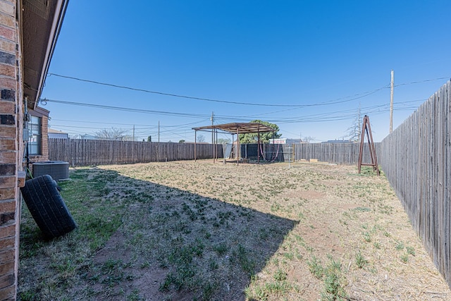 view of yard with central AC and a fenced backyard