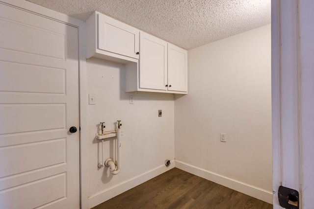 709 21st St, Lamesa, TX 79331 - laundry area featuring electric dryer hookup, dark wood-type flooring, a textured ceiling, and cabinet space
