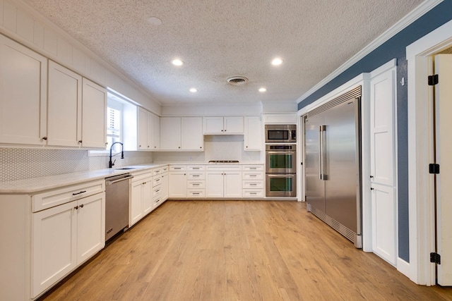 709 21st St, Lamesa, TX 79331 - kitchen featuring appliances with stainless steel finishes, ornamental molding, a textured ceiling, recessed lighting, and white cabinets