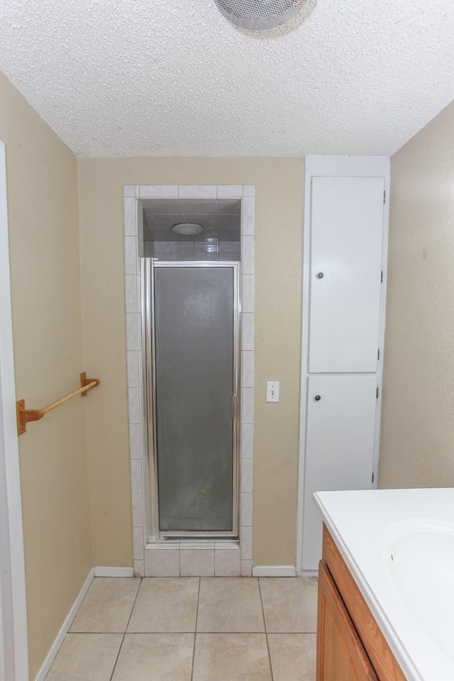 bathroom with tile patterned flooring, a textured ceiling, and vanity