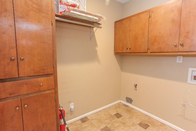 clothes washing area featuring hookup for a washing machine and cabinets