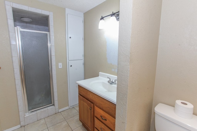 bathroom with a textured ceiling, vanity, toilet, and an enclosed shower