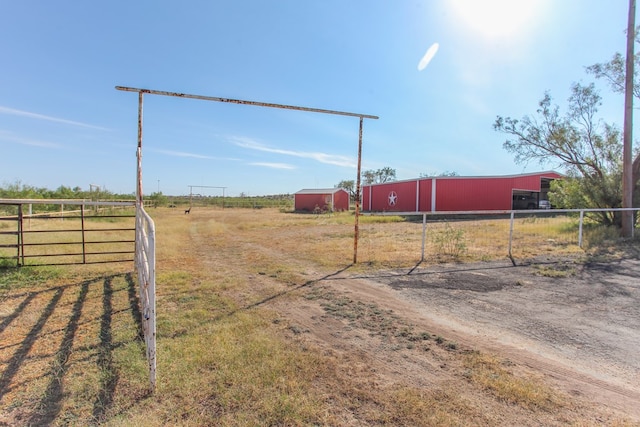 view of yard featuring a rural view and an outdoor structure